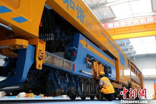 圖為工人正在清理大型養(yǎng)路機械。　張遠(yuǎn) 攝